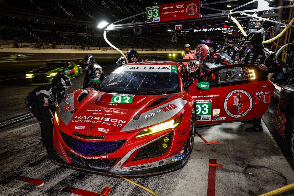 2023 red and silver Acura GT3 EVO at the 24 Hours of Daytona race in the pits